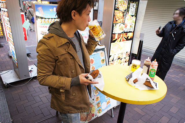 店先でアツアツの揚げ物を片手にお酒をグビッ